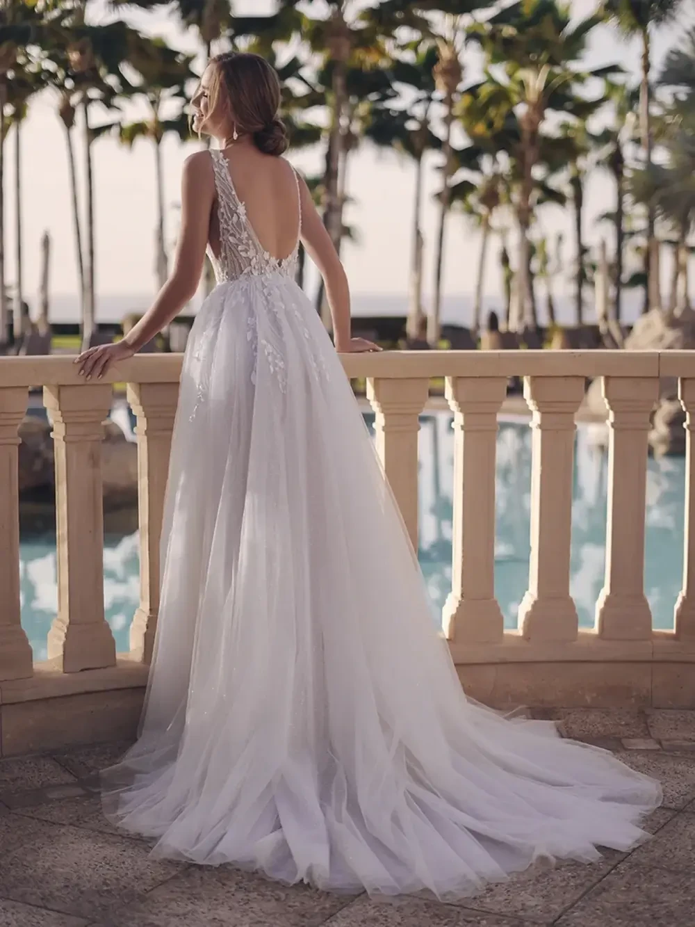 model is wearing an open back sleeveless lace bridal gown